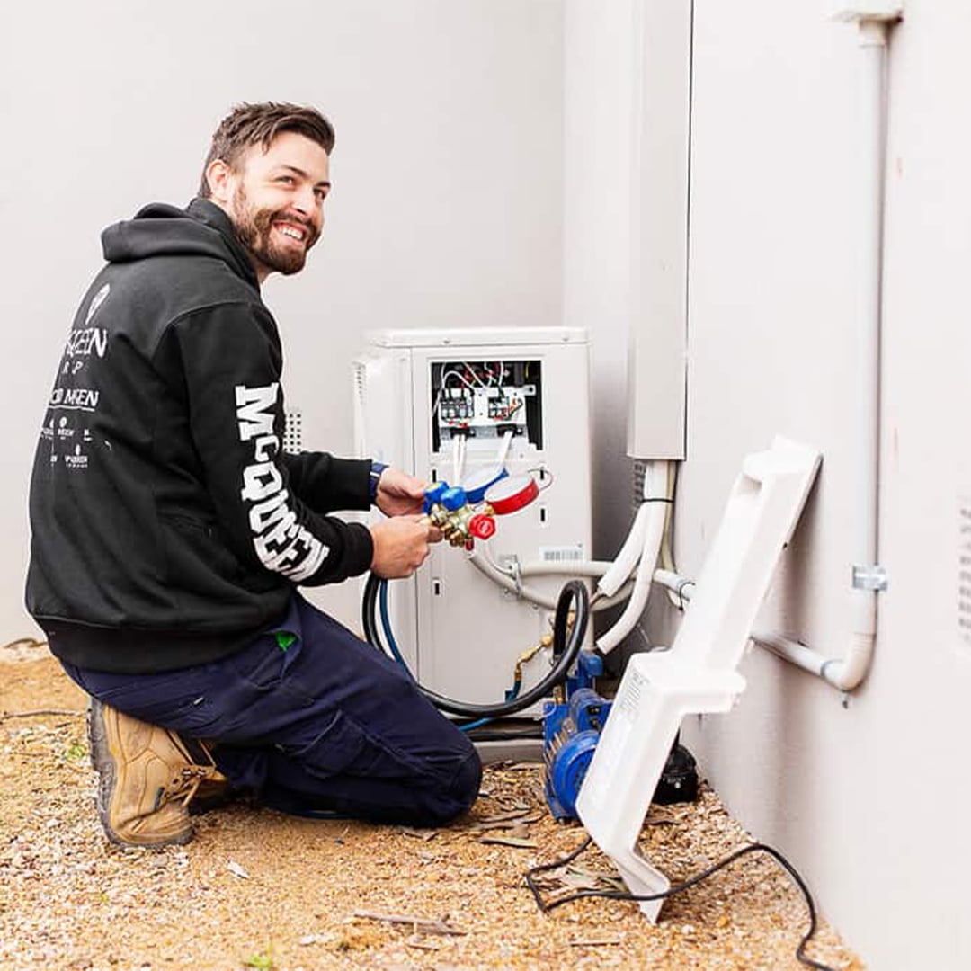 Professional HVAC Technician Servicing Outdoor AC Unit HVAC technician servicing an outdoor air conditioning unit using pressure gauges and tools.